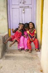 Three Indian Girls Sitting On A Doorstep Laughing
