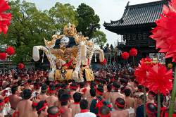 Large Group Of Naked Men Holding Colorful Pom Pom Like Decorations Carry A Golden Mikoshi Portable Shrine In The Nada Kenka Matsuri Fighting Festival In Himeji , Japan