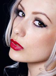 Portrait Of Pretty Young Woman With Blond Hair Against A Black Background