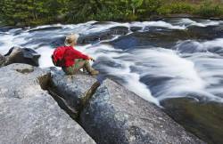 Hiker Along Waterfalls , Rushing River Provincial Park Near Kenora , Ontario , Canada