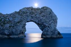 Durdle Door In The Moonlight , Dorset , England . Captured Late Evening As The Moonlight Flooded Through The Rocks Archway . Durdle Door Is One Of The Many Stunning Locations To Visit On The Jurassic Coast In Southern England .