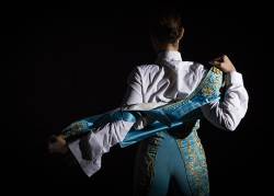 Woman Bullfighter By Dressing With Vest On Your Back On A Black Background