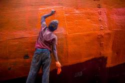 A Painter Is Painting A Repaired Ship In Dock Yard , Dhaka .