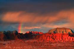 Sunset On A Breaking Thunderhead Clouds With A Verticle Rainbow Over Goblin Valley From Goblin Valley State Park In Utah