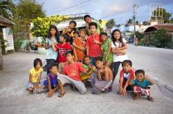 A Large Group Of Filipino Children Come Together In The Road For An Informal Group Portrait In Bogo City , Cebu Island , Philippines , Southeast Asia .