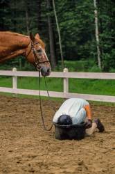 Teenage Horseback Rider Drinks From Horse’s Water Tub