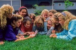 A Group Of Teenage Girls Share A Letter From Home At A Summer Camp In Vermont , United States , North America .