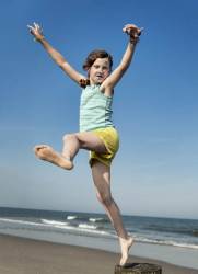 Girl Playfully Jumping From A Beach Pier, Stone Harbor, New Jersey, USA