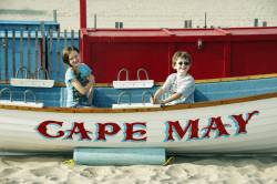 Kids Pose In A Lifeguard Rescue Boat On The Beach In Cape May, New Jersey, USA