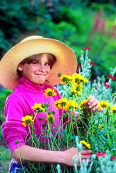 A Cute Nine Year Old Girl With An Impish Smile Picks Flowers In Her Garden At Plainfield , New Hampshire , United States .