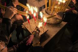 Lighting Incense Sticks At The Famous Man Mo Temple, Hong Kong , China.