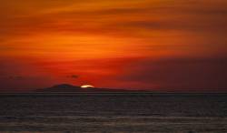 Vivid Red, Gold And Orange Tropical Sunset Over A Small Island In The Verde Island Passage Near Puerto Galera, Oriental Mindoro Island, Philippines.