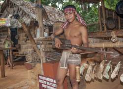 A Teenage Palawano Tribesman Plays A Native Filipino Guitar, Paglong, To Entertain Tourists Visiting The Palawan Eco Butterfly Garden And Tribal Village Located In Puerto Princesa, Palawan Island In The Philippines.