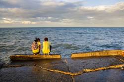 Teenage Filipino Boy And Girl Share A Quiet Moment Together In The Seawall Facing The Open Ocean At Cadiz City, Negros Occidental Island, Philippines.
