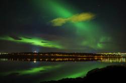 Auroras Borealis Reflecting In The Water And Over The Pearl And Fossvogur, Reykjavik, Iceland