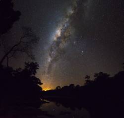 The Milky Way Seen From Brazilian Rainforest Along The Shore Of Rio Cristalino, Southern Amazon. Mosaic Of 2 Images. The Orange Glow Is The Lights From The City Of Alta Floresta. Mars And Saturn Together With The Orange Star Antares Form The Triangle Just To The Right (west) Of The Galactic Centre.