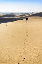 Woman Walking In The Dunes, Early In The Morning. Al Faqaa, Dubai Emirates, United Arab Emirates