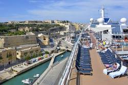 Sun Deck Of A Large Tall Modern Cruise Liner With Views Over Valletta City & Passengers  Sunbathing Rather Than Going Ashore