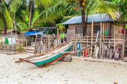 Seaside Home Of A Filipino Fishing Community Family With An Outrigger Canoe At Nueva Valencia, Guimaras Island, Philippines.