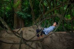 Cambodian Teen Relaxes On A Vine Swing Deep In A Jungle Village At Banteay Srei, Kingdom Of Cambodia.
