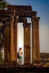 Female Traveler Prays During Sunrise At Ankar Wat Temple In Siem Reap, Cambodia.