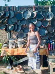 Young Woman Selling Used Pots And Pans In The Street