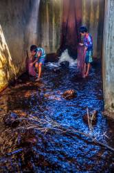 Two Young Cambodian Boys Catch Fish With Homemade Nets In A River Spillway At Banteay Srei, Cambodia.