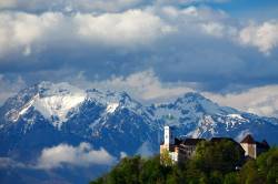 View Across The City To Ljubljana Castle With The Snowcapped Kamnik Alps Forming A Picture Perfect Background.