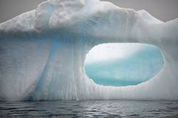 Iceberg With An Oval Window Created By Erosion, Antarctica
