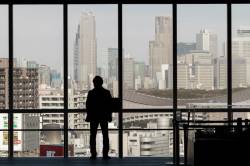 A Salaryman In Silhouette Looks Out Of The Windows Of The Hikarie Tower With The Skyscrapers Of Shinjuku In The Distance. Shibuya, Tokyo, Japan. Friday February 17th 2017