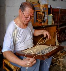 A Chinese Artisan Weaving In Armenian Street, George Town, Penang, Malaysia