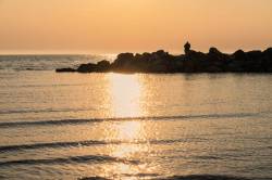 Sunset Over The Sea At Ahrenshoop Man Sea Fishing Off Rocks, Mecklenburg-Vorpommern, Germany