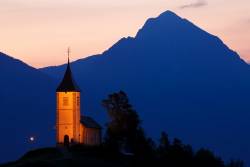 Jamnik Church Of Saints Primus And Felician At Dawn, Perched On A Hill On The Jelovica Plateau With The Kamnik Alps And Storzic Mountain In The Background, Slovenia.