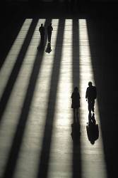 Sunshine Streaming Through Narrow Windows To Create Banded Shadows Across Paved Area People Manipulated Colours