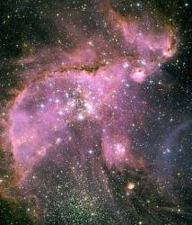 This Hubble Space Telescope View Shows One Of The Most Dynamic And Intricately Detailed Star Forming Regions In Space , Located 210 , 000 Light Years Away In The Small Magellanic Cloud ( SMC ) , A Satellite Galaxy Of Our Milky Way At The Centre Of The Region Is A Brilliant Star Cluster Called NGC 346 A Dramatic Structure Of Arched , Ragged Filaments With A Distinct Ridge Surrounds The Cluster A Torrent Of Radiation From The Hot Stars In The Cluster NGC 346 , At The Centre Of This Hubble Image , Eats Into Denser Areas Around It , Creating A Fantasy Sculpture Of Dust And Gas The Dark , Intricately Beaded Edge Of The Ridge , Seen In Silhouette , Is Particularly Dramatic It Contains Several Small Dust Globules That Point Back Towards The Central Cluster , Like Windsocks Caught In A Gale