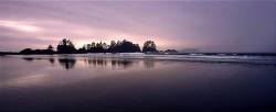 Waves Roll Onto Chesterman Beach As The Sun Breaks Through The Clouds